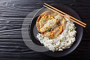 Crispy fluffyÂ egg fooÂ young filled with crisp veggies and aromatic green onion and served with a rice close-up. horizontal top